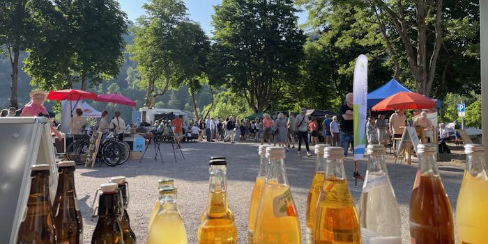 Getränkestand auf dem Naturpark-Abendmarkt mit Blick auf die Marktfläche unter Bäumen